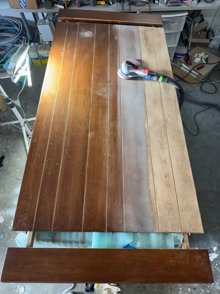 A wooden door being sanded, highlighting the prep stage before exterior house painting with a sander on top.