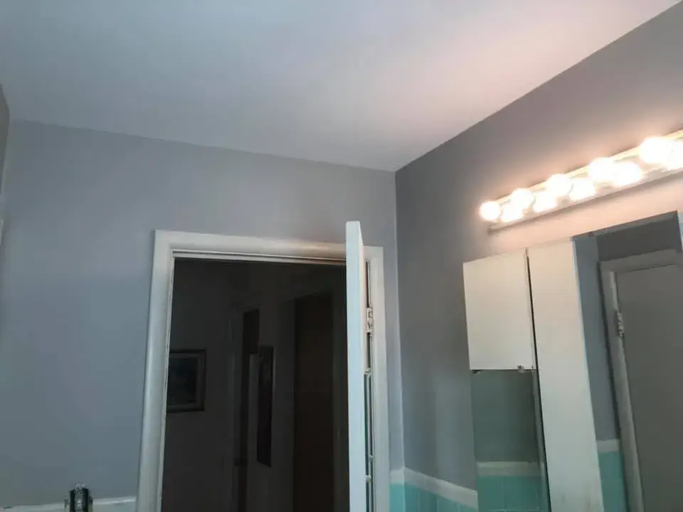 After: bathroom with teal tile: peeling walls repaired and repainted