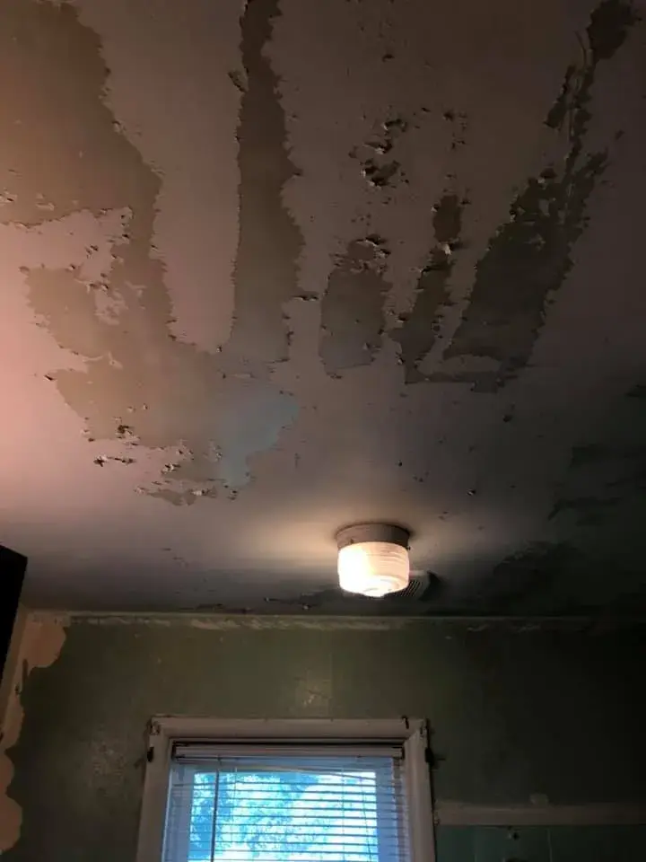 Ceiling with extensive peeling paint above a light fixture and a window. - My Personal Painter - My Personal Painter Before: bathroom with teal tile: peeling walls repaired and repainted