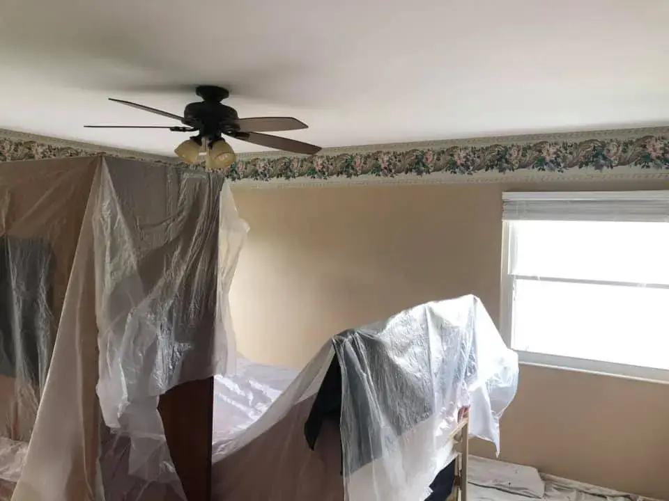 Furniture in a room covered with plastic sheeting for protection. - My Personal Painter - My Personal Painter Before: bedrooms with wallpaper borders painted gray