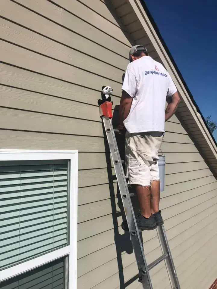 In progress: brick and tan siding house exterior painted