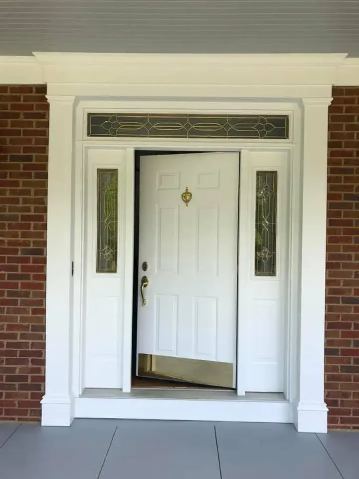 After: brick home: round wraparound porch and rear deck with brick columns
