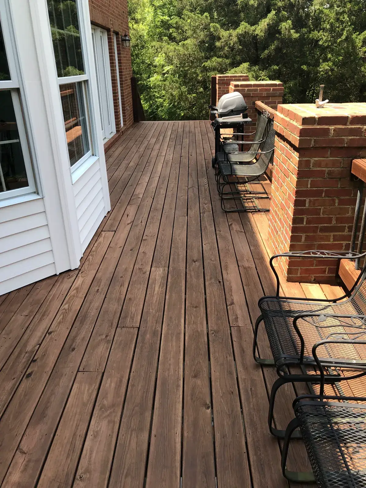 After: brick home: round wraparound porch and rear deck with brick columns