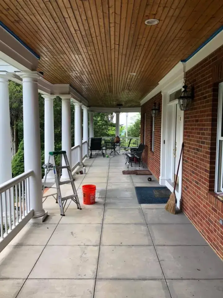 A brick house porch with a wood-paneled ceiling, white columns, a step ladder, and an orange bucket. - My Personal Painter - My Personal Painter Before: brick home: round wraparound porch and rear deck with brick columns
