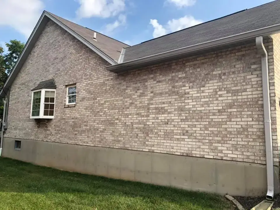 Before: brick ranch exterior painted light gray