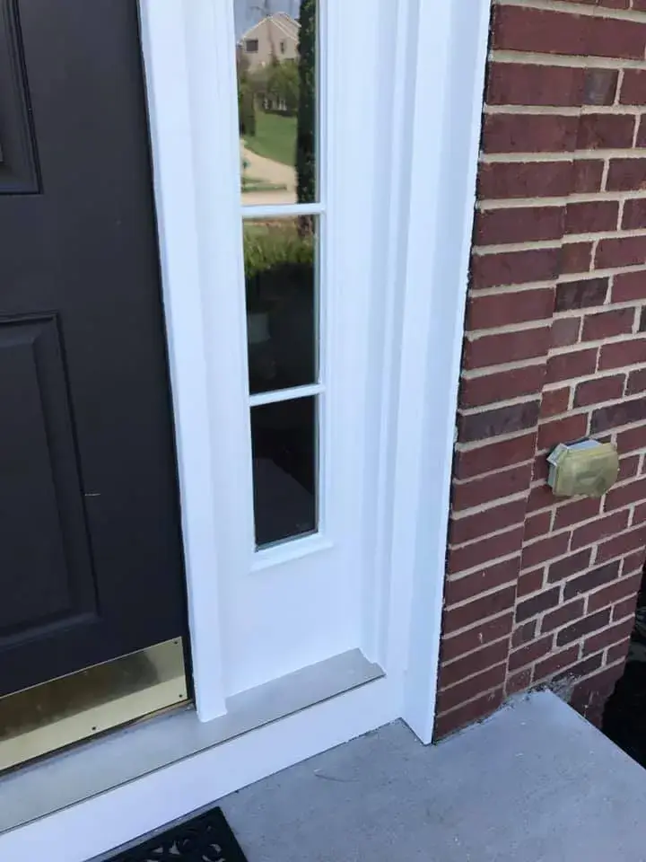 After: brick two-story front entry: rotted trim repaired, trim painted white, red door painted black