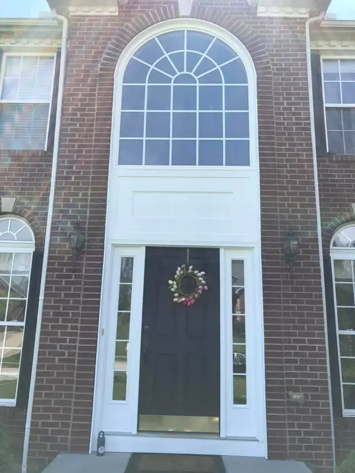 After: brick two-story front entry: rotted trim repaired, trim painted white, red door painted black