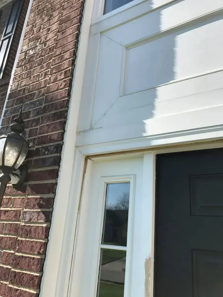 After: brick two-story front entry: rotted trim repaired, trim painted white, red door painted black
