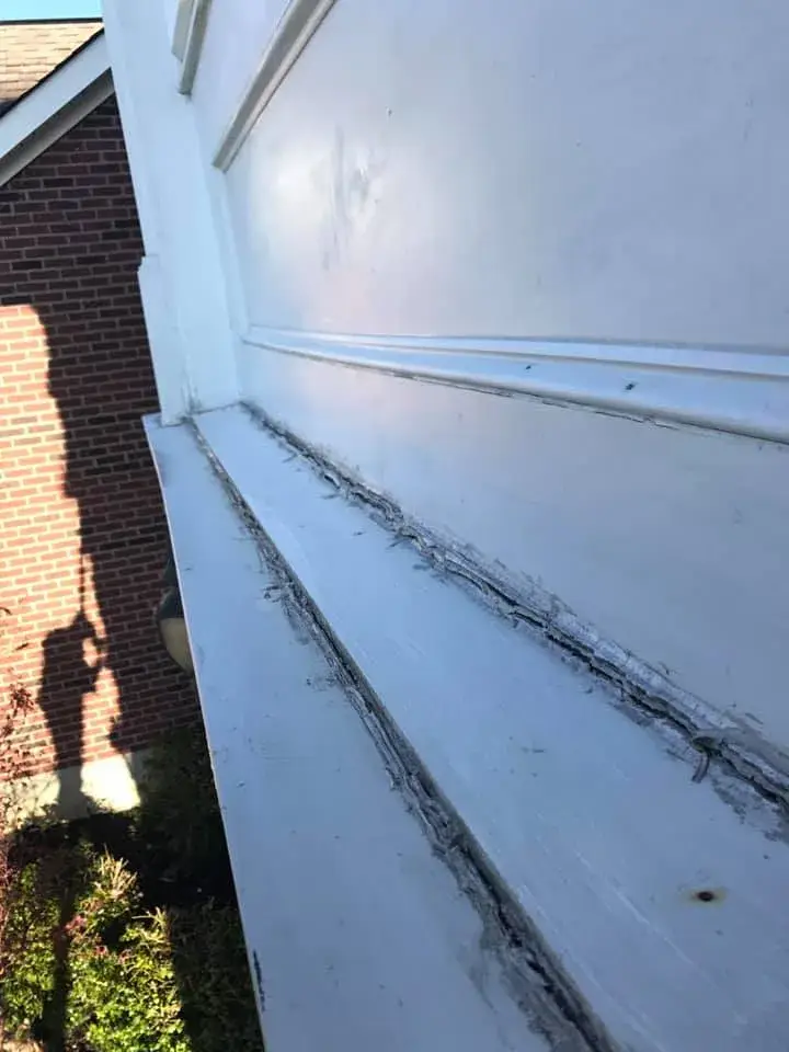 Before: brick two-story front entry: rotted trim repaired, trim painted white, red door painted black