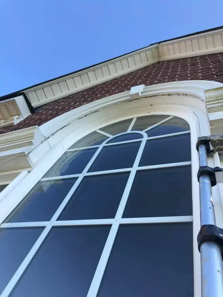 Before: brick two-story front entry: rotted trim repaired, trim painted white, red door painted black