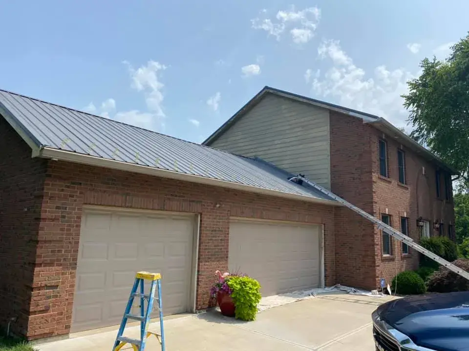 Before: brick two-story house: siding and trim painted