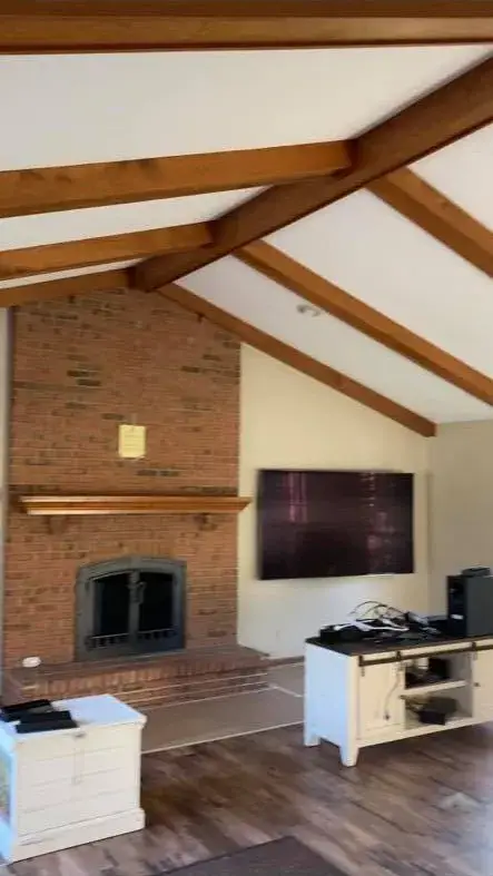 Before: ceiling beams painted black, brick fireplace whitewashed, other rooms