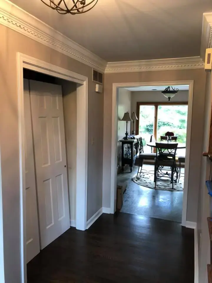 After: foyer, pool table room and dining room: wood trim painted white