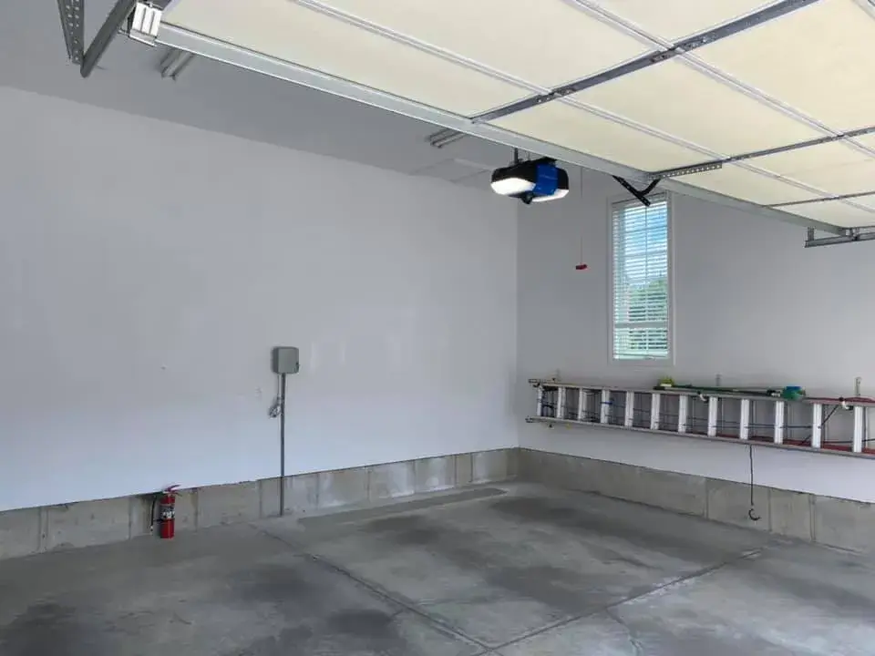 After: great room with tray ceiling and arched window, garage painted white