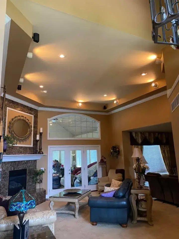 After: great room with tray ceiling and arched window, garage painted white