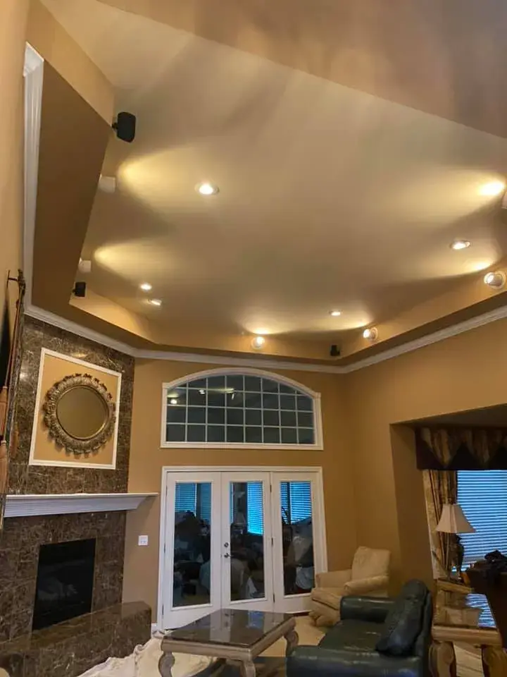 Before: great room with tray ceiling and arched window, garage painted white