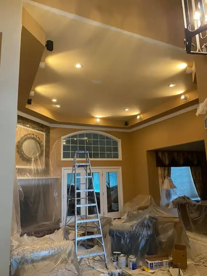 In progress: great room with tray ceiling and arched window, garage painted white