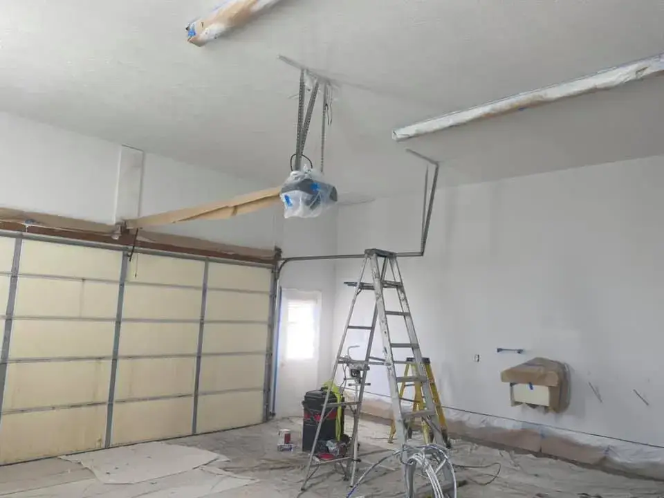 In progress: great room with tray ceiling and arched window, garage painted white