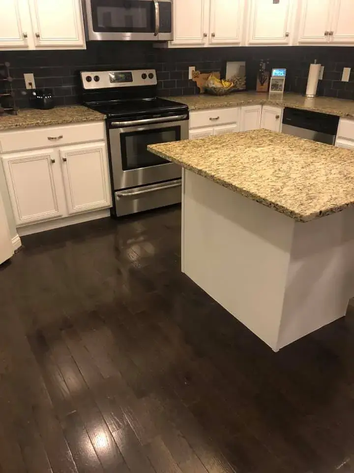 After: kitchen cabinets glazed and painted white with a granite island