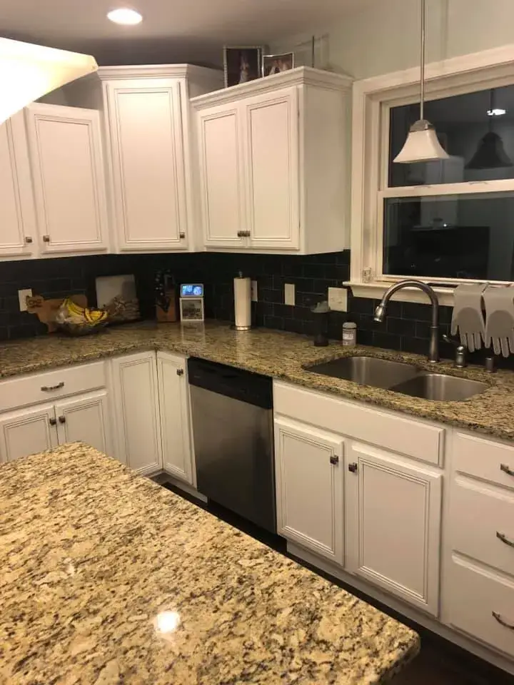 After: kitchen cabinets glazed and painted white with a granite island