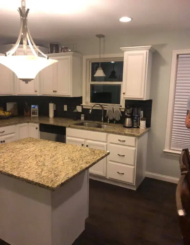 After: kitchen cabinets glazed and painted white with a granite island