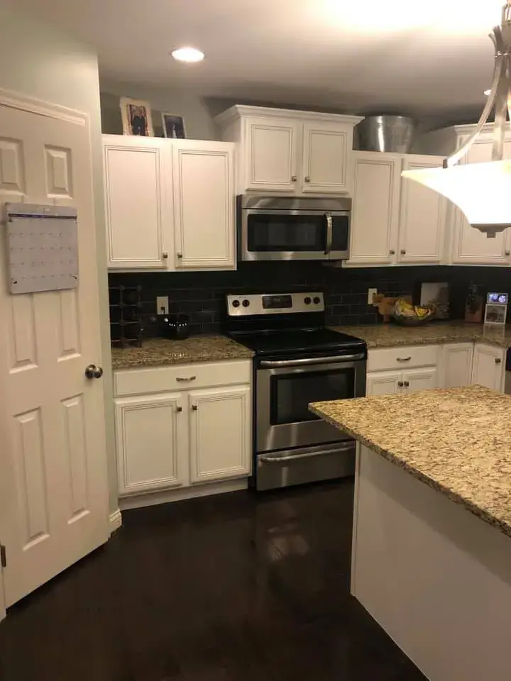 After: kitchen cabinets glazed and painted white with a granite island