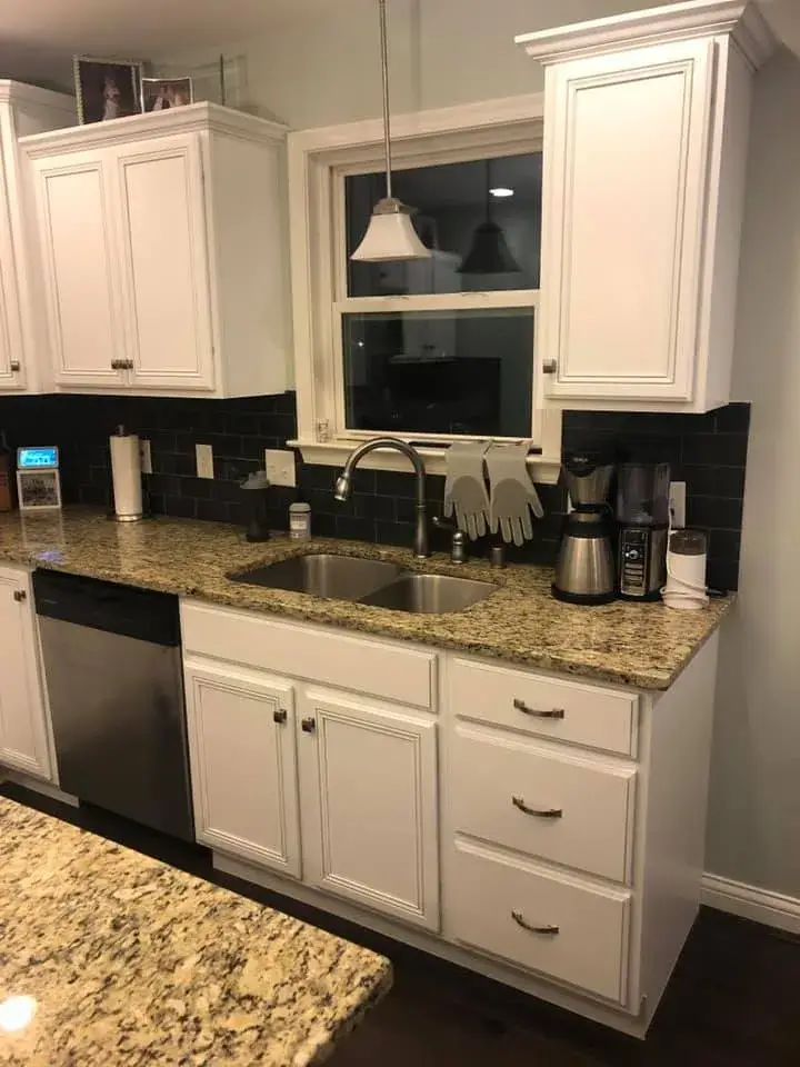 After: kitchen cabinets glazed and painted white with a granite island