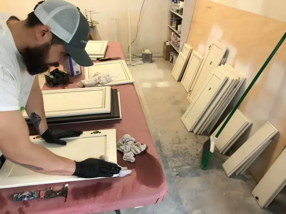 In progress: kitchen cabinets glazed and painted white with a granite island