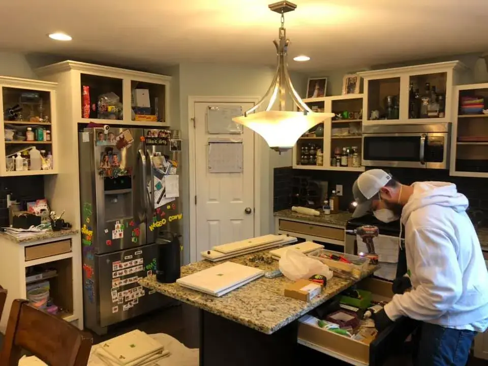 In progress: kitchen cabinets glazed and painted white with a granite island