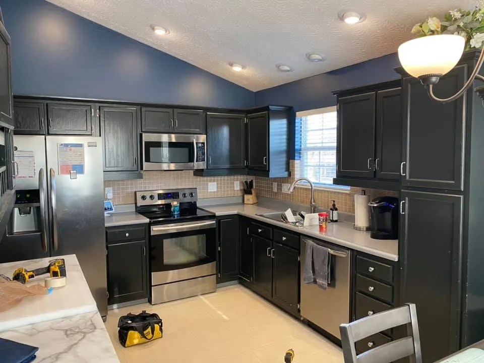 After: kitchen cabinets painted black under navy walls