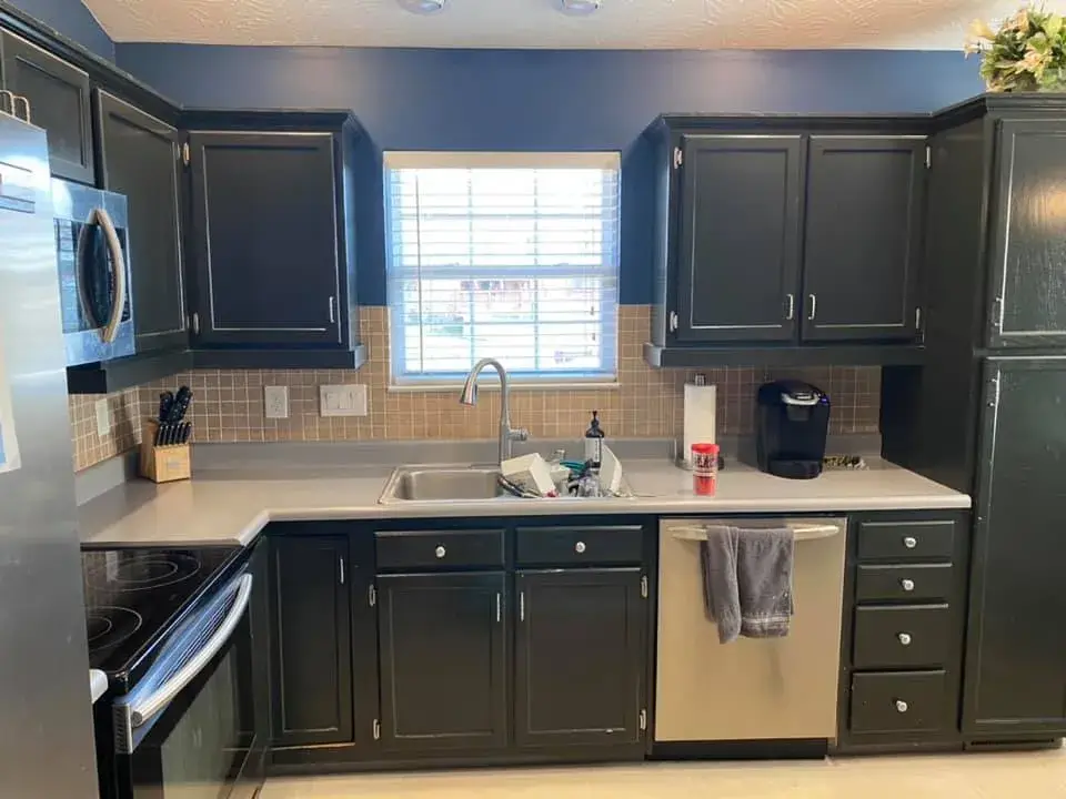 After: kitchen cabinets painted black under navy walls