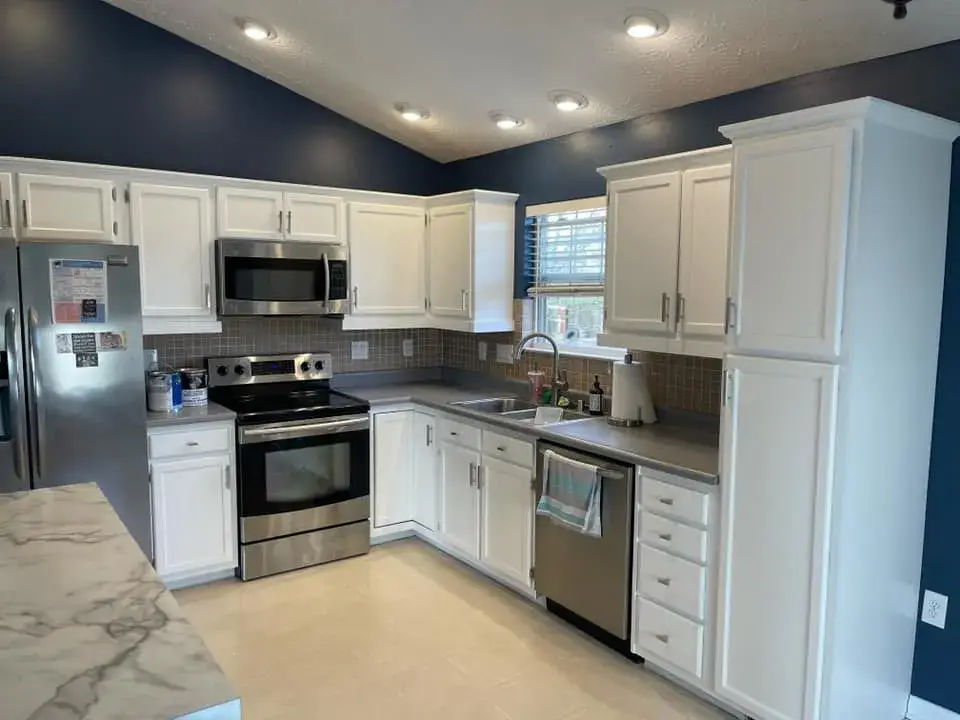 Before: kitchen cabinets painted black under navy walls