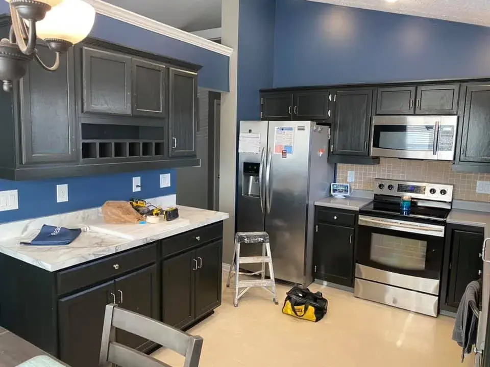 In progress: kitchen cabinets painted black under navy walls