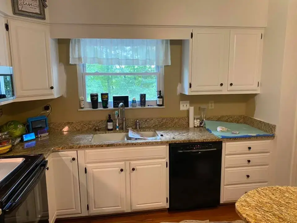 After: kitchen cabinets painted white, granite counters