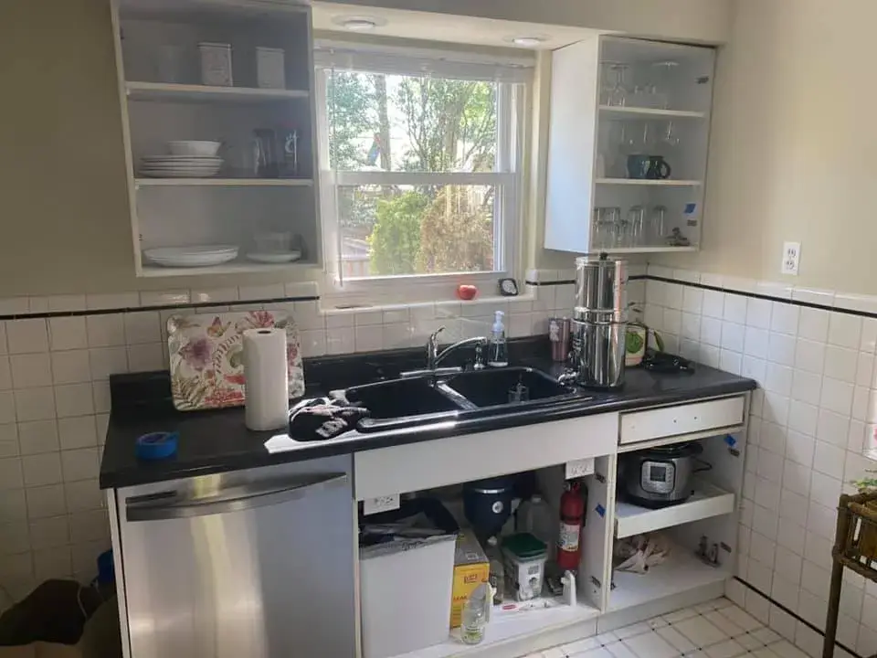 Kitchen sink area with open upper cabinets, black countertops, and under-counter appliances. - My Personal Painter - My Personal Painter Before: kitchen cabinets: white to olive green