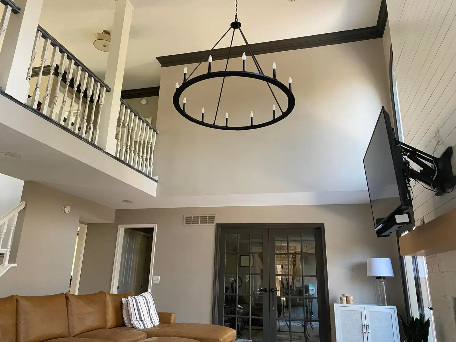 After: kitchen cherry cabinets to white with a green island, two-story great room, dining room and foyer