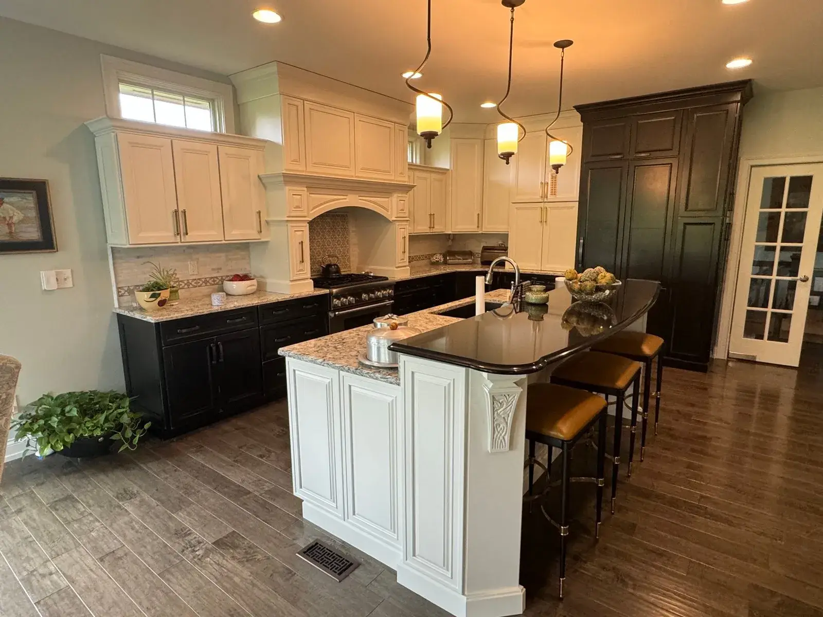 After: kitchen glazed sage cabinets painted white, dark lowers and pendant lights