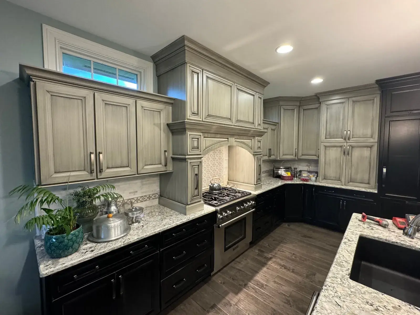 Before: kitchen glazed sage cabinets painted white, dark lowers and pendant lights
