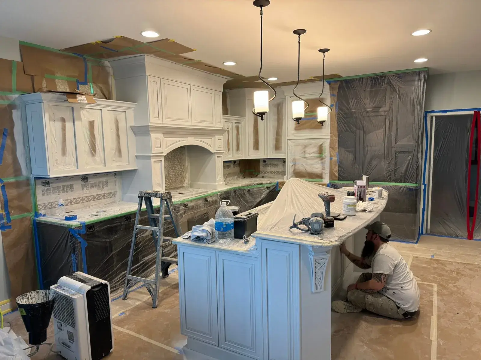 In progress: kitchen glazed sage cabinets painted white, dark lowers and pendant lights