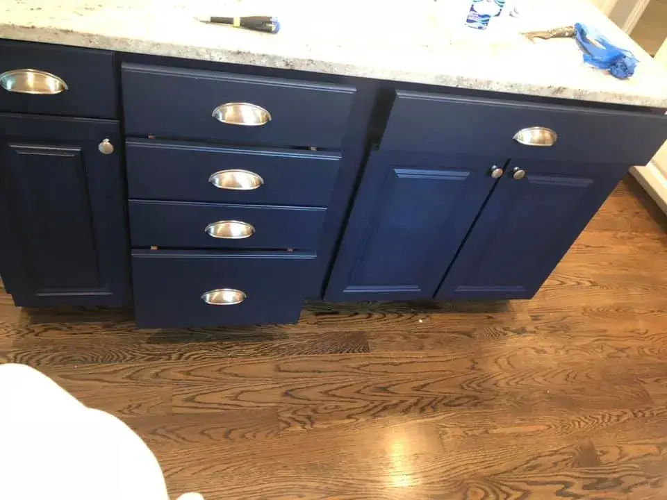 Navy blue bathroom vanity cabinets with silver pulls on a wood floor. - My Personal Painter - My Personal Painter After: kitchen island painted navy