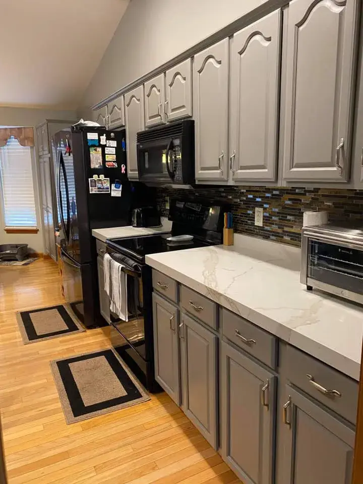 After: kitchen oak cabinets painted gray, vaulted ceiling with beam