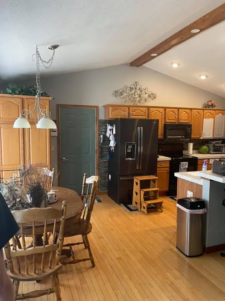 Before: kitchen oak cabinets painted gray, vaulted ceiling with beam