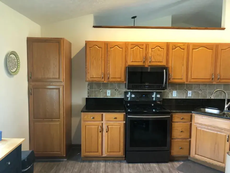 Before: kitchen oak cabinets painted white uppers with dark green lowers