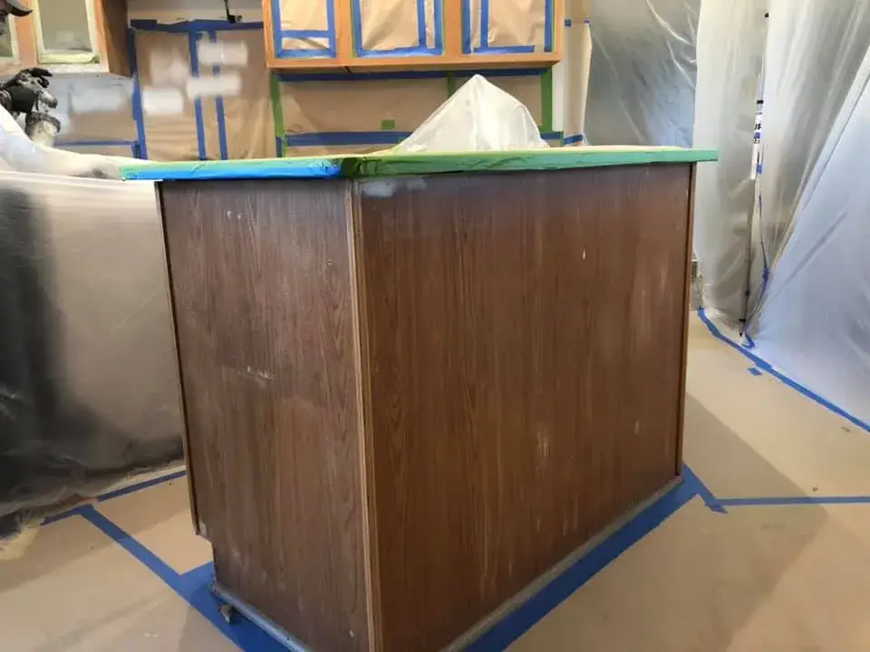 In progress: kitchen oak cabinets painted white uppers with dark green lowers