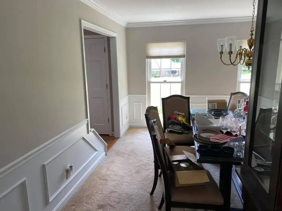 Dining room with a table, chairs, and a chandelier, viewed from an entryway. - My Personal Painter - My Personal Painter After: kitchen painted white, living room and dining room repainted