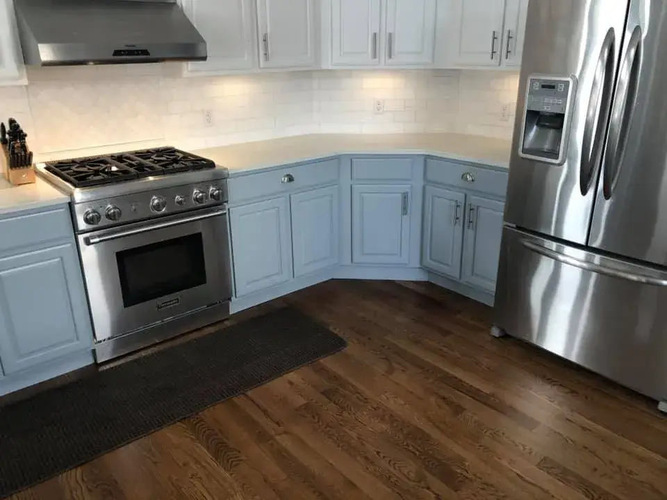 After: kitchen with arched window: cabinets refinished, white uppers and blue-gray lowers