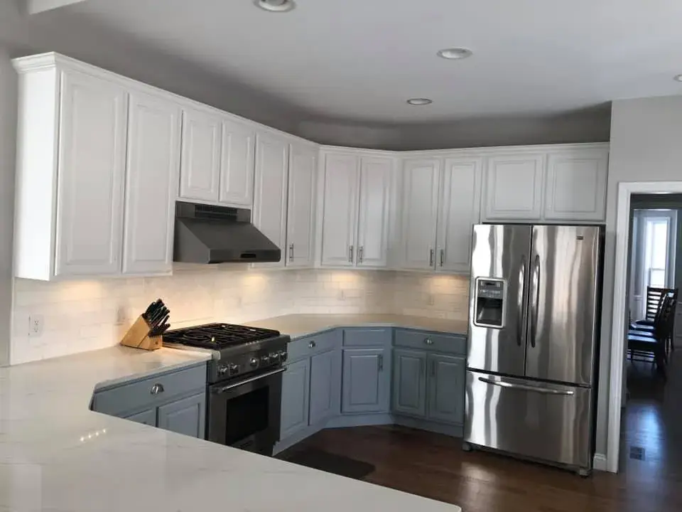 After: kitchen with arched window: cabinets refinished, white uppers and blue-gray lowers