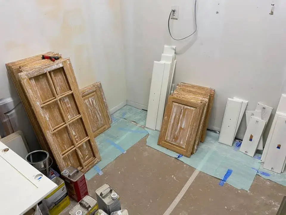 In progress: kitchen with arched window: cabinets refinished, white uppers and blue-gray lowers