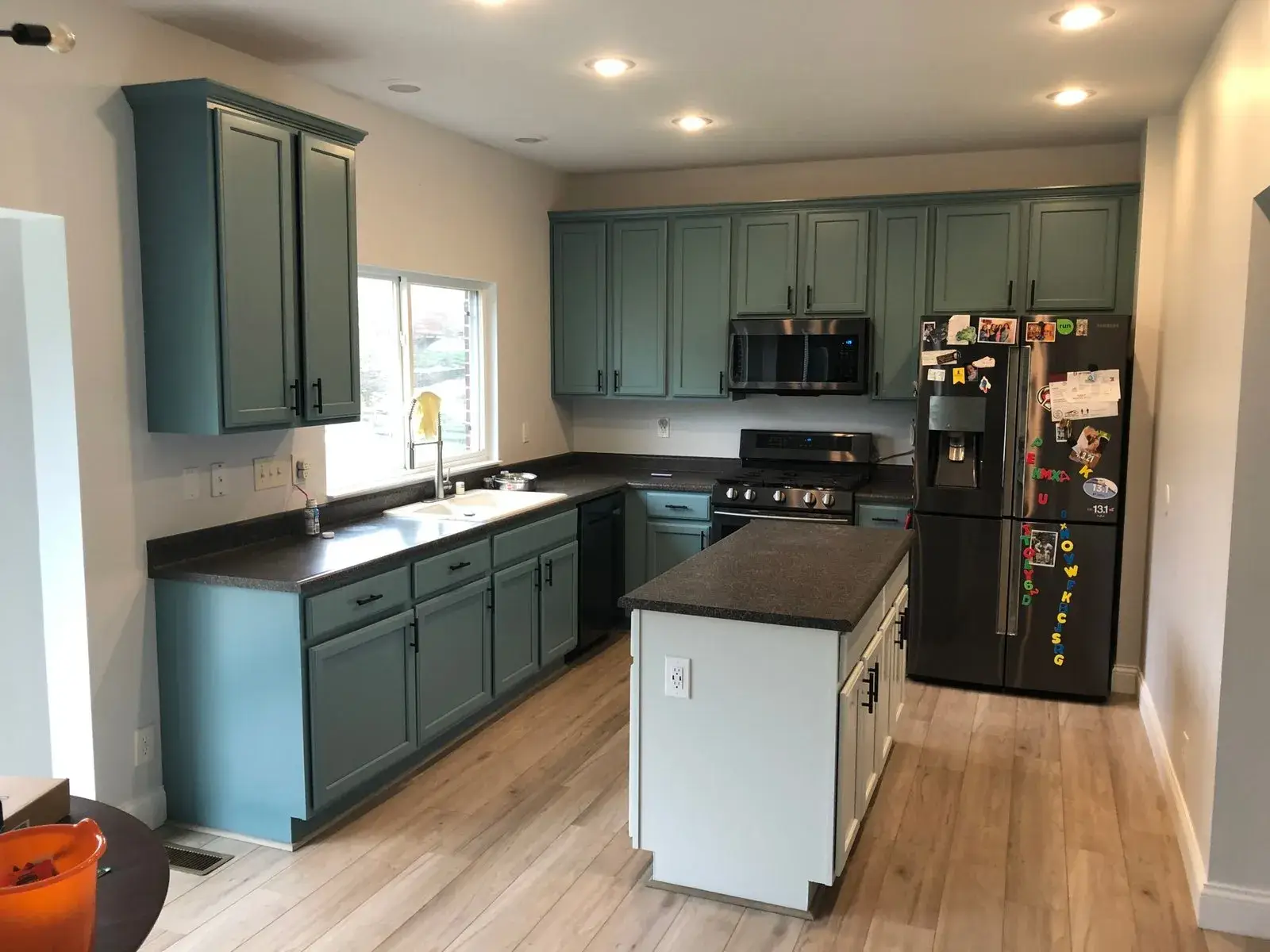 After: kitchen wood cabinets painted teal with a white island