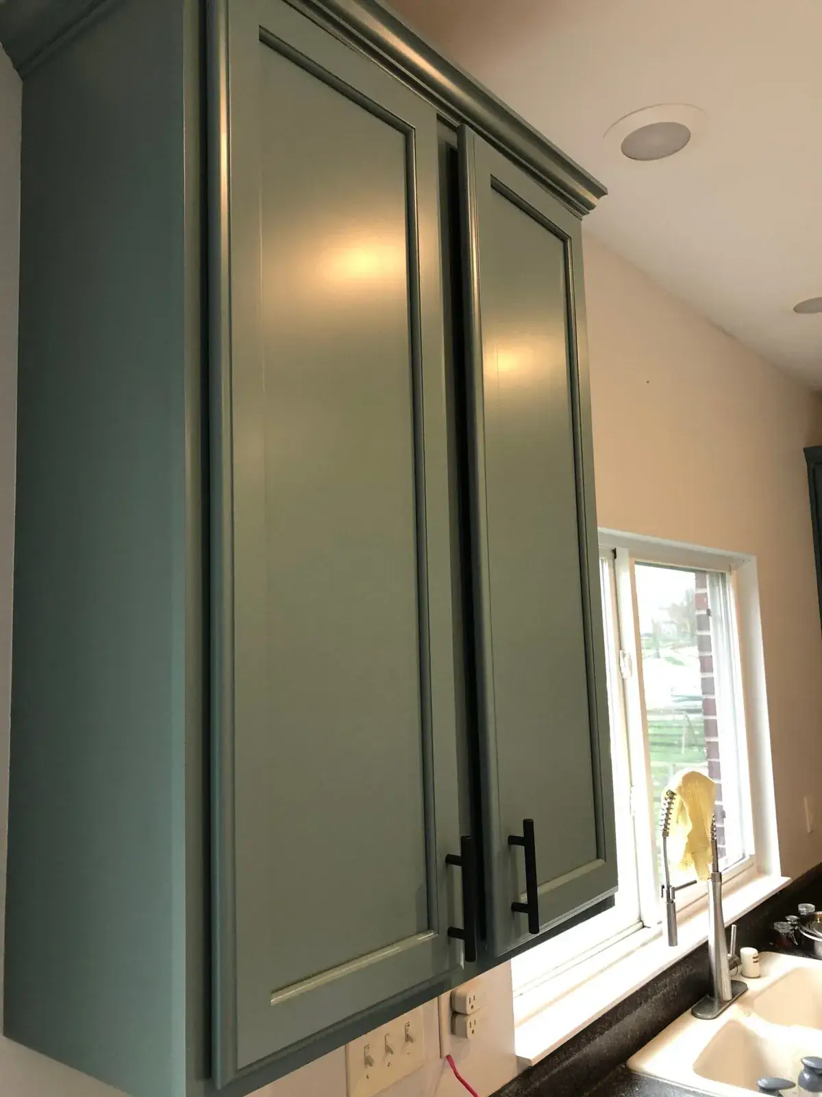 After: kitchen wood cabinets painted teal with a white island